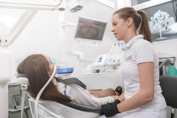a dentist looking at the patient on the dental chair