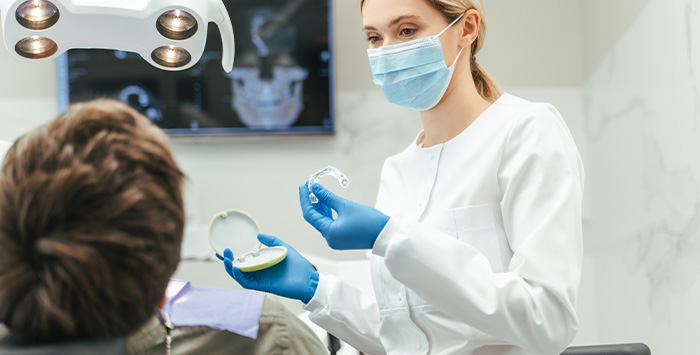 Dentist showing patient clear aligner in treatment room