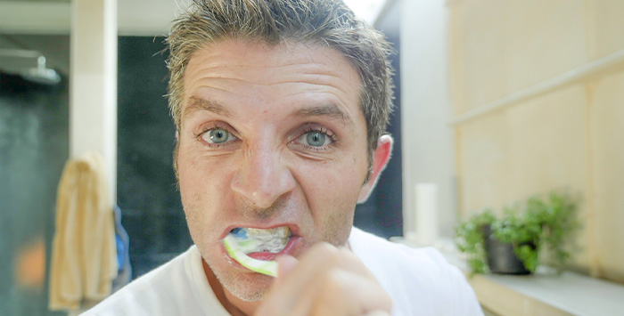 Man brushes teeth
