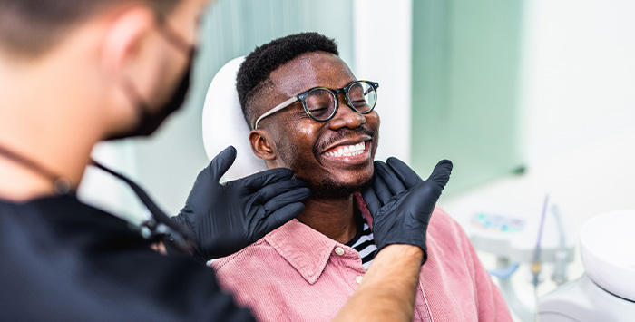 Dentist looking at patient's smile in treatment room.