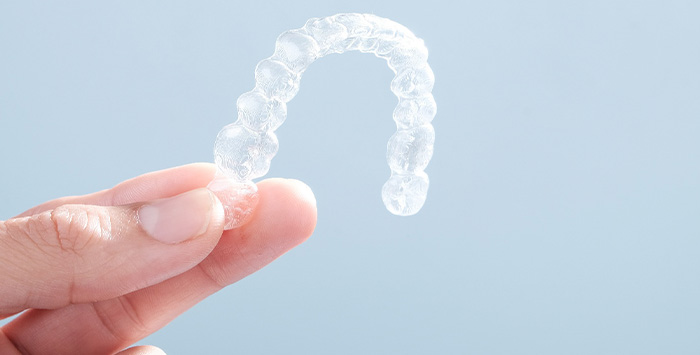 Patient holding clear aligner.